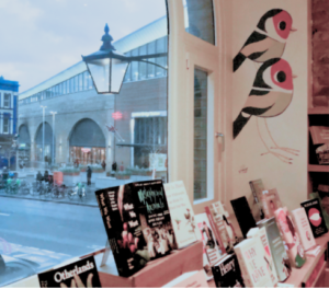 the inside of the Riverside Bookshop with a view through the window of London Bridge station