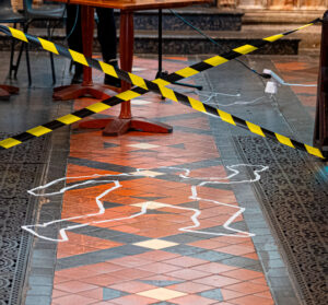 photo of a body outlined in tape on a tiled floor and criss-crossed crime scene tape.